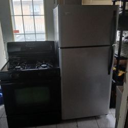 Frigidaire Stainless Steel fridge and black Maytag stove 