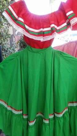 Blusa roja con olan y falda verde.
