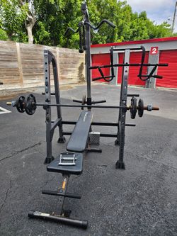 Heavy-duty black steel power rack with integrated lat pulldown cable attachment, multiple cable handles and rope attachment, weight plate storage pegs