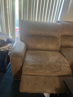 Black refrigerator and brown sofa