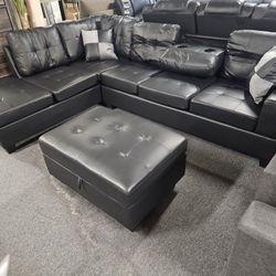 Brand New 108" x 80" Black Faux Leather Reversible Sectional With Cup Holders And Storage Ottoman