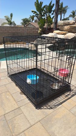 Medium sized dog crate with bowls