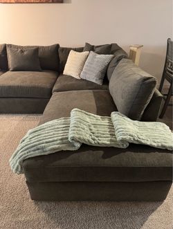 A Jerome’s charcoal sectional with a chaise, about 15 months old and with no damage pillows included