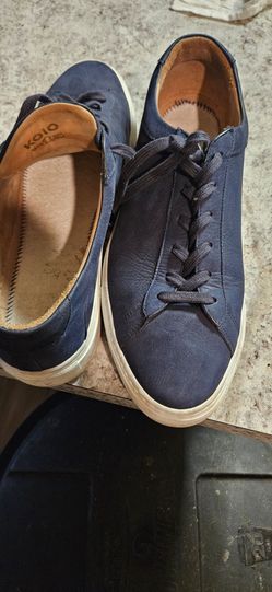 Knavy blue Koio Capri low-top sneakers featuring a tan leather interior lining and a white rubber sole
