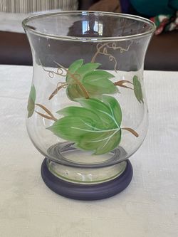 Hand-painted glass hurricane candle holder with floral motif and colored base.