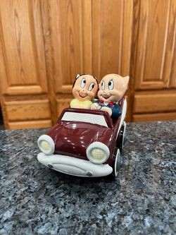 Vintage Warner Brothers Porky Pig and Petunia Pair of Salt and Pepper Shakers in Classic Car Holder. Size approximately 4 3/4 inches by 5 1/2 inches
