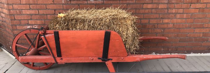 Antique wooden wheelbarrow with iron frame wheel