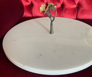 This is a Michael Aram Butterfly Ginkgo Lazy Susan featuring a handcrafted, patinated brass branch and white marble base