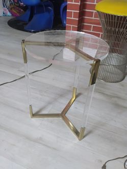 MCM Beautiful round acrylic side table with brass armature. Has one chip on surface of table top