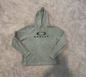 green Oakley pullover hoodie features a large black logo on the chest and a worn-in, washed texture (Size XL but fits like a L)