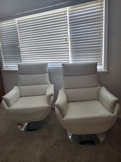 Two white swivel chairs