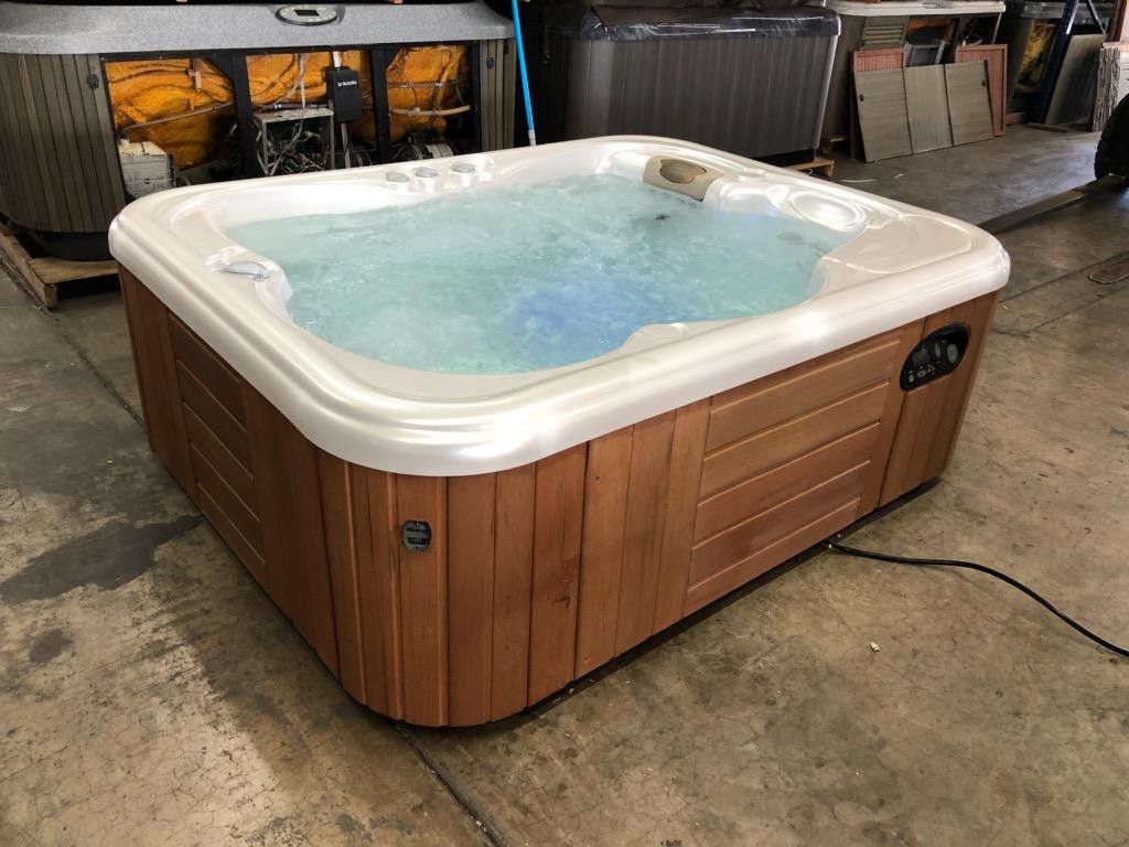 Dozens of pre-owned hot tubs of different types and sizes.