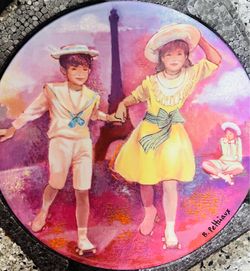 This is a 1985 "Patinage au Trocadéro" collector plate by artist Bernard Peltriaux, manufactured in Limoges, France.