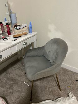 Grey upholstered chair with gold legs