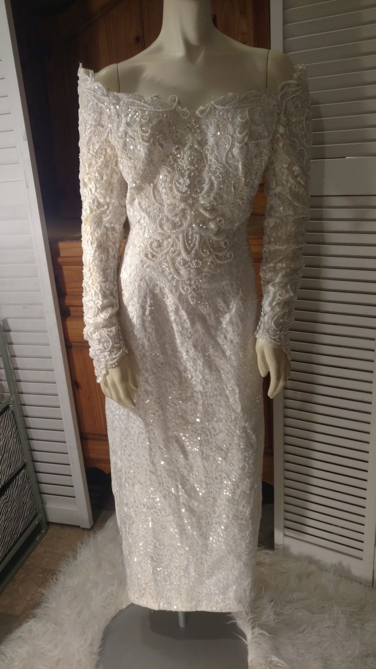 Eden Bridals such a beautiful Exquisite wedding gown! It is long-sleeved off shoulders it is adorned with beads and pearls and gems! Size 10!