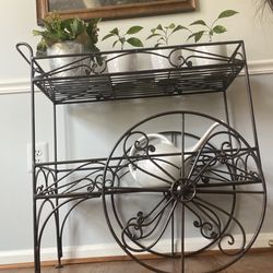 Wrought iron tiered plant stand with wheels in a great condition.