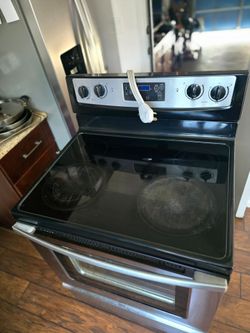 Whirlpool electric stove with glass cooktop and oven.