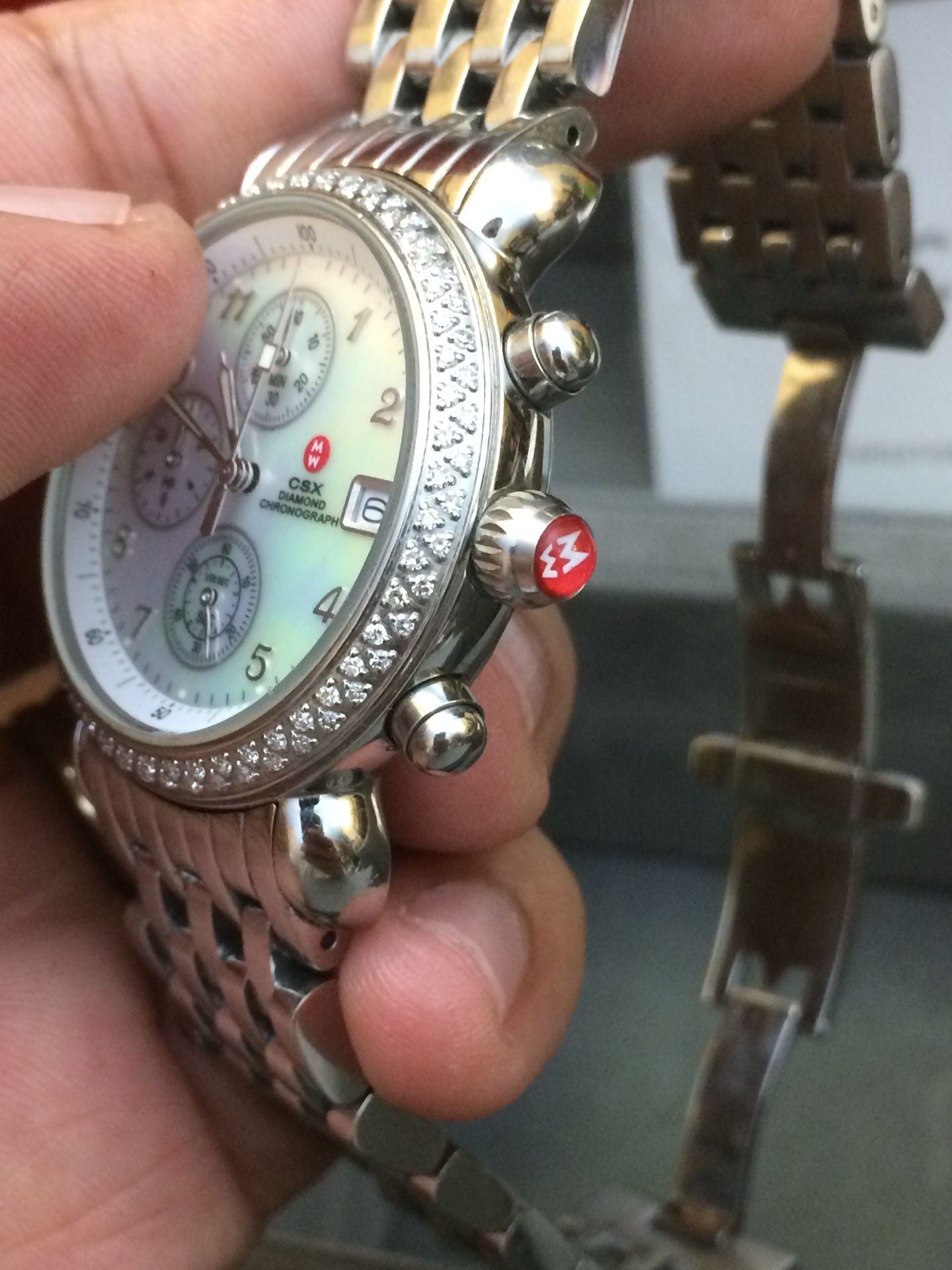 Michele Csx Diamond Chronograph watch comes in silver tone stainless steel and features a round, mother of pearl clock face, with diamond frame.