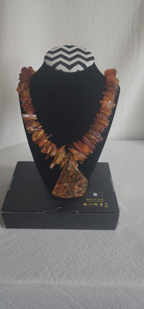 long amber necklace has a medallion