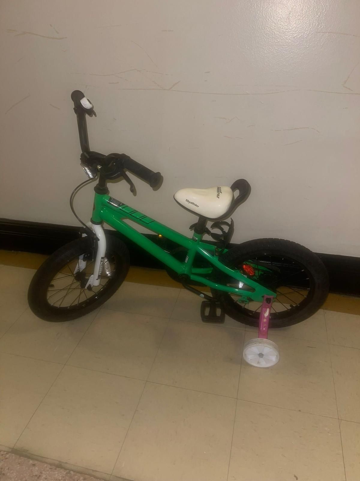 Green kids bike. Includes training wheels. Great for younger children learning to ride. bicycle, likely a 14-16 inch model, designed for children a