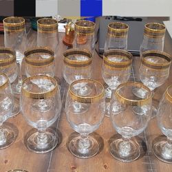 collection of crystal glasses and cups with gold rims