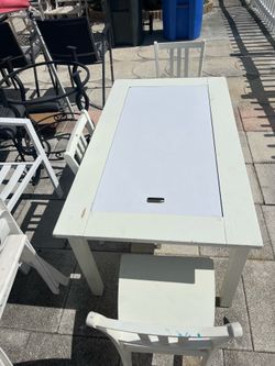 Solid wood table and three chairs in good condition, featuring a tabletop that also functions as a chalkboard, along with a paper roll for drawing and
