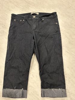Dark denim jeans with frayed cuffs.