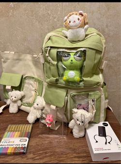Versatile green and cream canvas ita bag set includes a backpack and a tote bag with clear display windows. The set comes with three small white plush