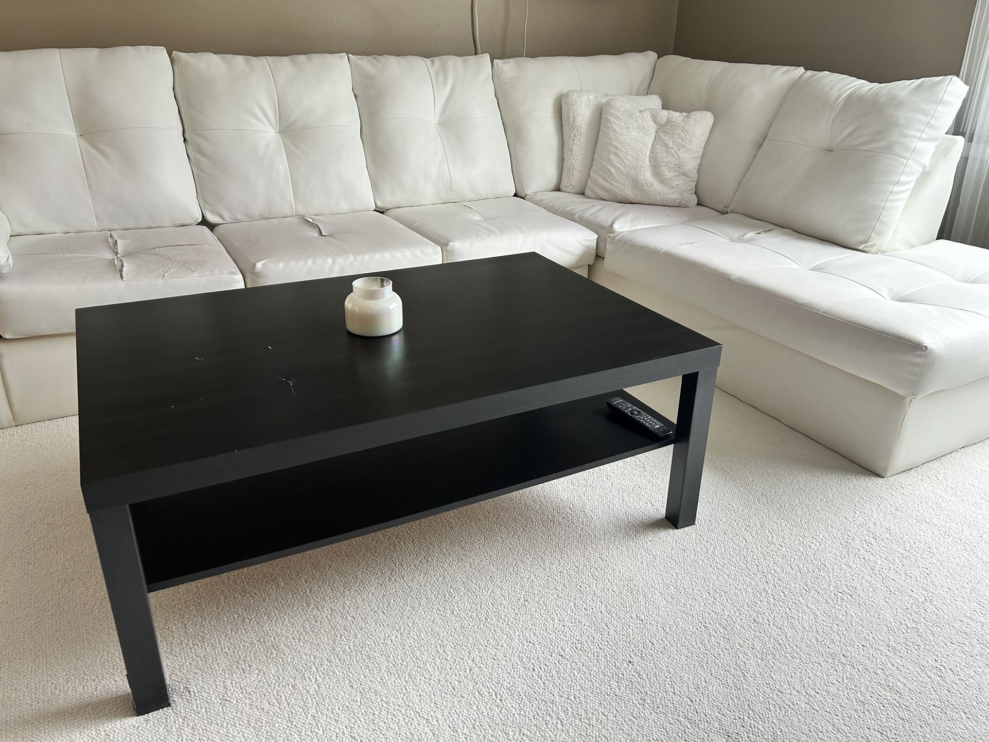 White sectional couch with black table