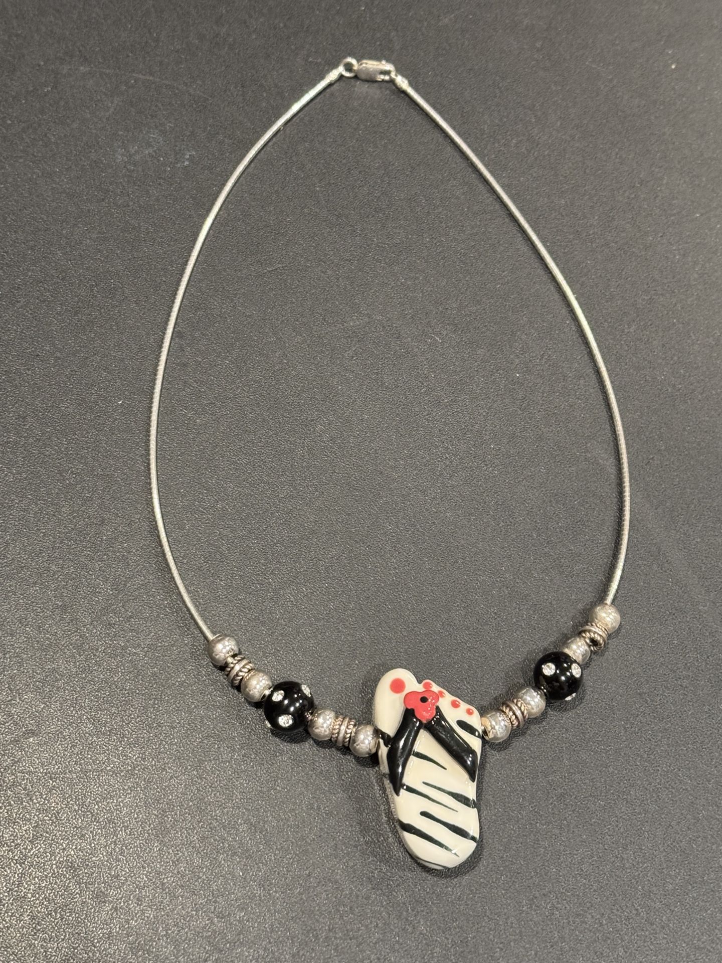 Sterling Silver necklace. Marked Italy .925. Nice statement piece w/ Ceramic Sandal plus Sterling & ceramic beads. 16” length.