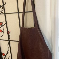 Here's a large Italian leather tote bag in a beautiful burgundy color. It's an oversized bag perfect for everyday use or travel. The leather has a nic