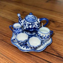 A blue and white miniature ceramic tea set with floral decoration.