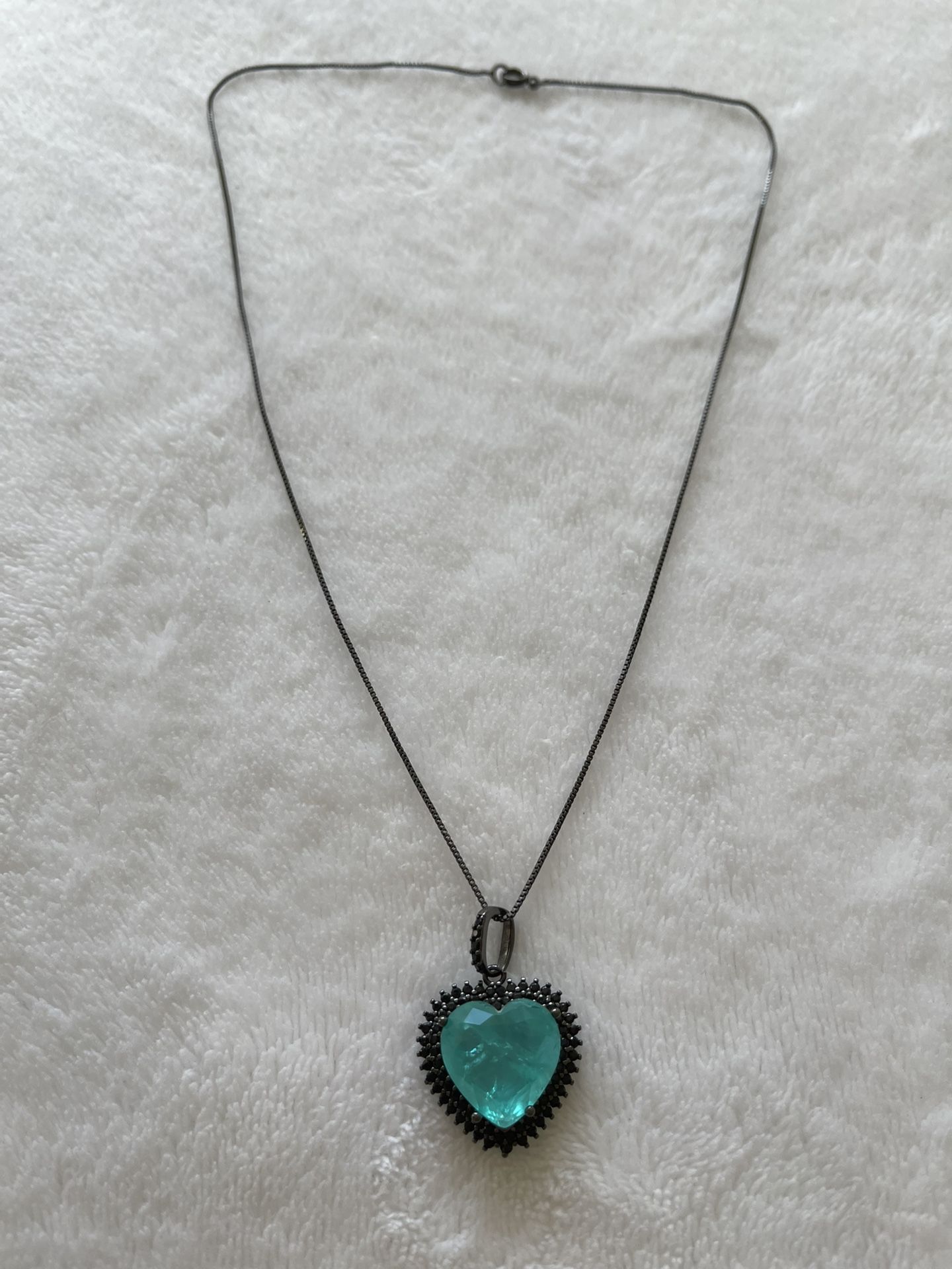 black rhodium plated necklace with turquoise heart stone and several black swarovisk.