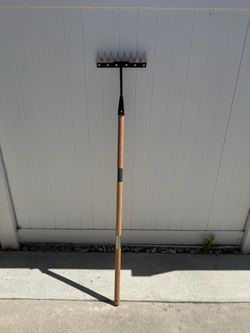 Iron grass rake with long wooden handle