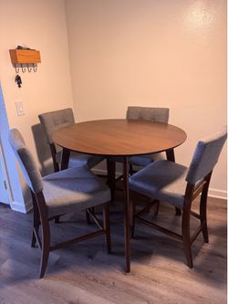 Grey Couch and Round Table With Four Chairs