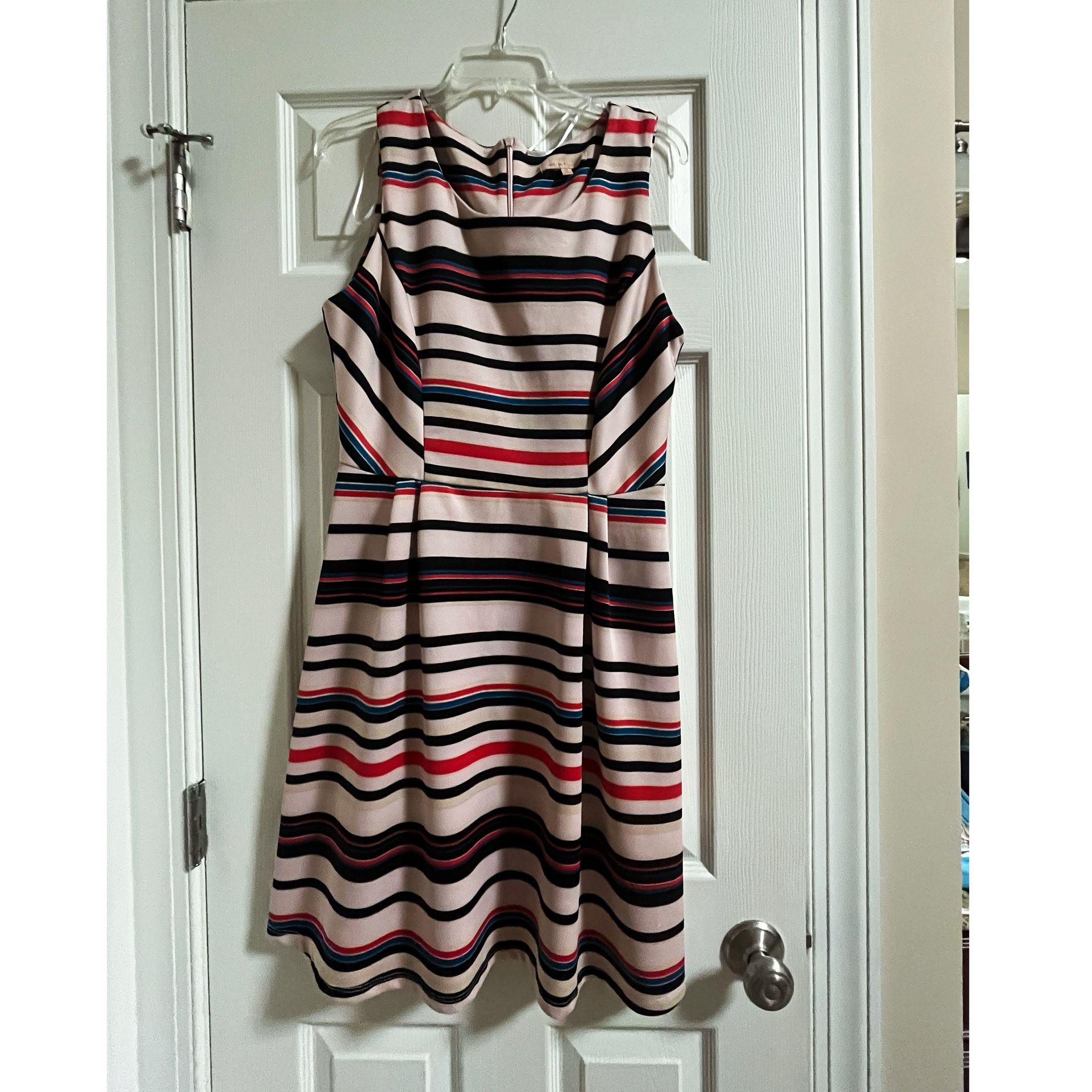 Elegant sleeveless dress by Gibson Latimer with a soft cream background and horizontal black, soft red, and subtle blue stripes. Flattering fit-and-fl