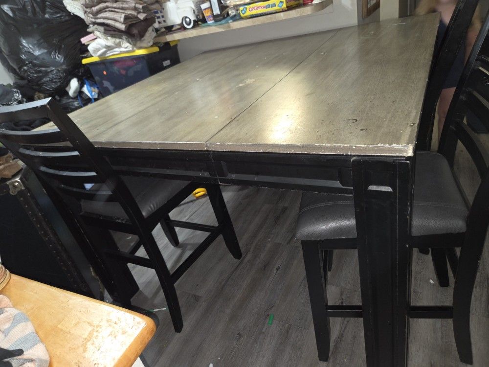 Counter-height dining table set with 4 matching chairs.