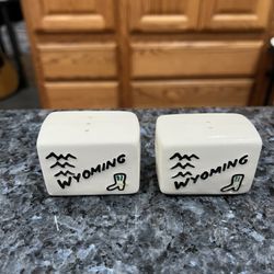 Vintage Souvenir Wyoming Milford Pottery Pair of Salt and Pepper Shakers.  Size approximately 2 inches wide and 1 1/4 inches tall.  Preowned no stoppe