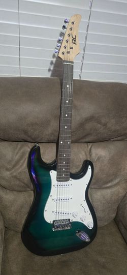 Vibrant electric guitar. Has green and blue burst finish body with white pickguard. Features three single-coil pickups, tremolo bridge, volume knob, t