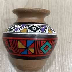 Peruvian Incan pottery, featuring traditional geometric patterns in colors black, white, red, yellow, and blue. 