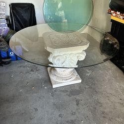Round Glass-Top Table with Ornate Stone Pedestal Base