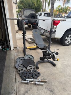 Bench press/squat rack with 7ft bar plus 180lbs of Olympic weights and dumbbells handles