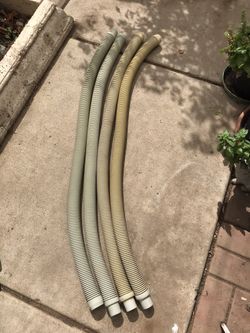 Four gray colored, used pool cleaner hoses