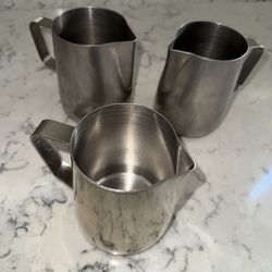 Three 24 oz steaming pitchers, with etchings inside