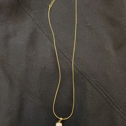 Gold necklace with simple charm 