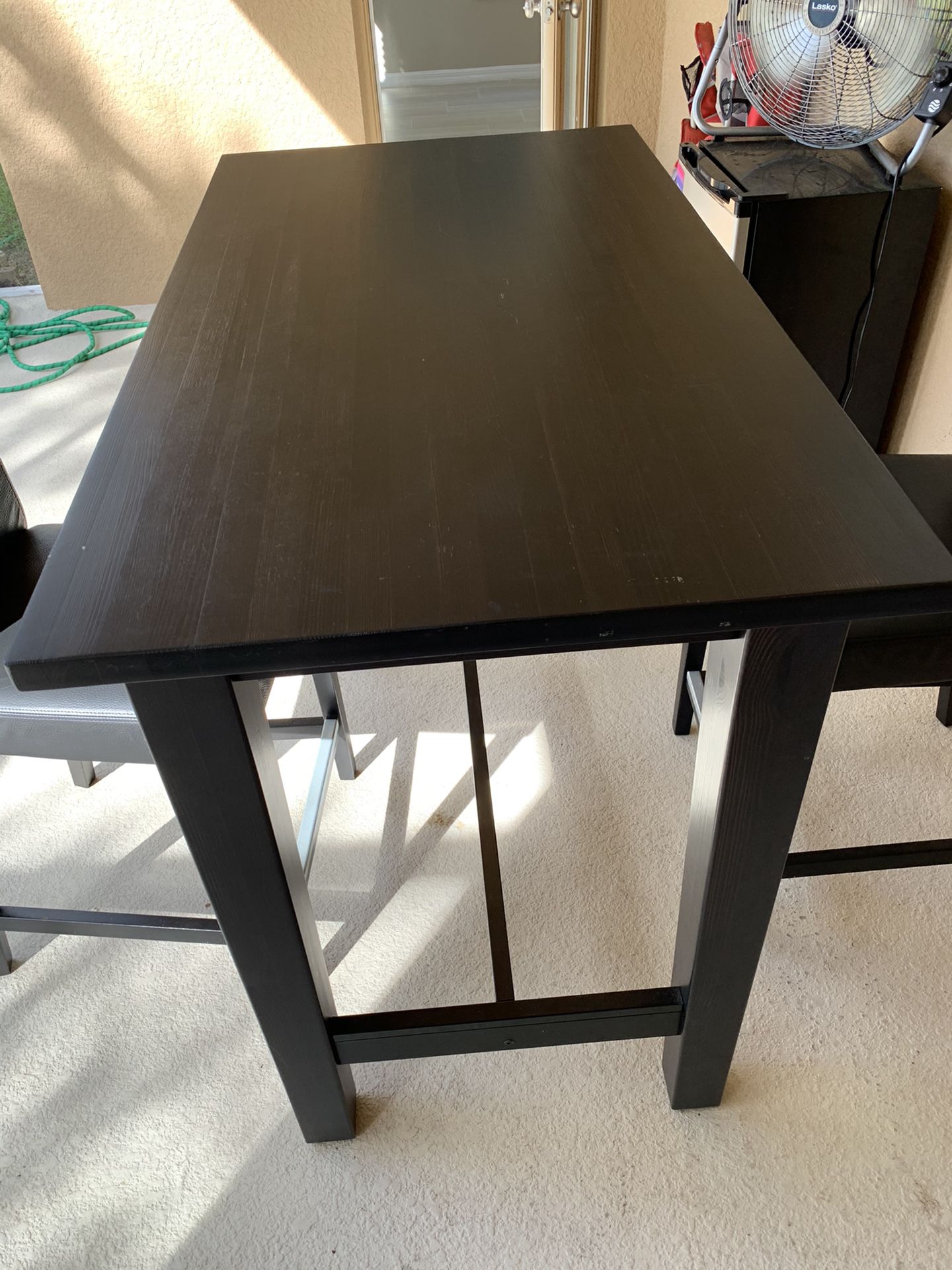 Tall dark table with 2 bar stool chairs. 4ft x 28in x 42in