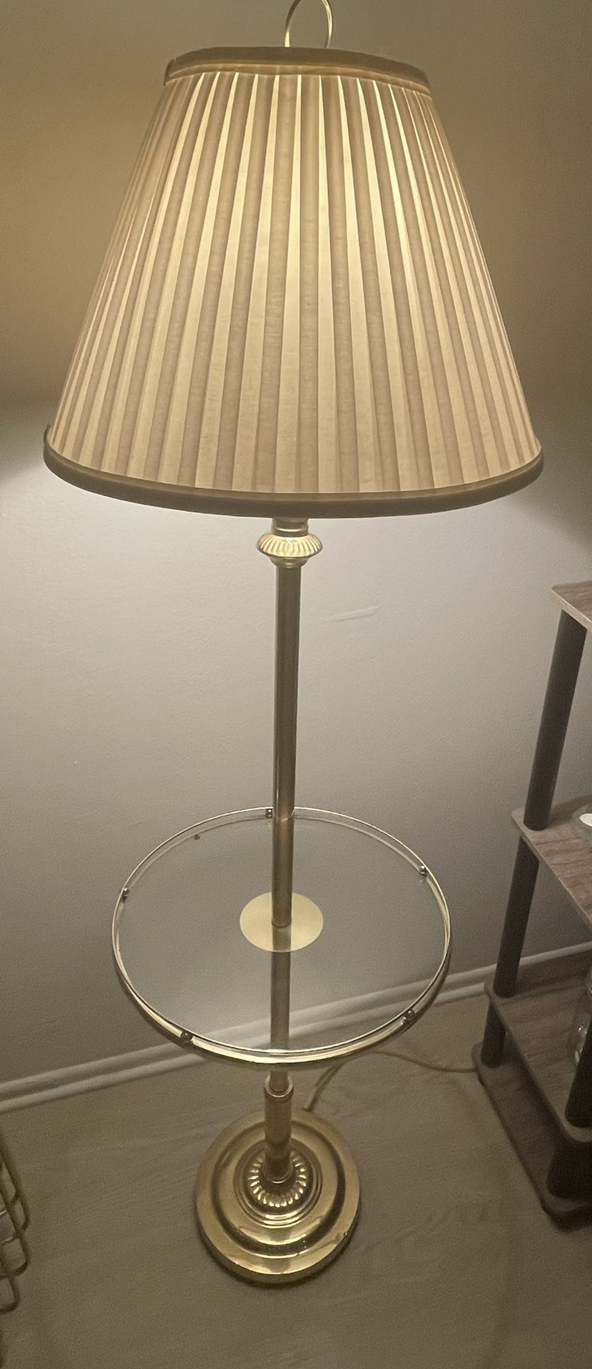 Vintage gold floor lamp with white shade and round glass table.