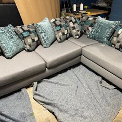 Grey Sectional With Tourquise Pillow 