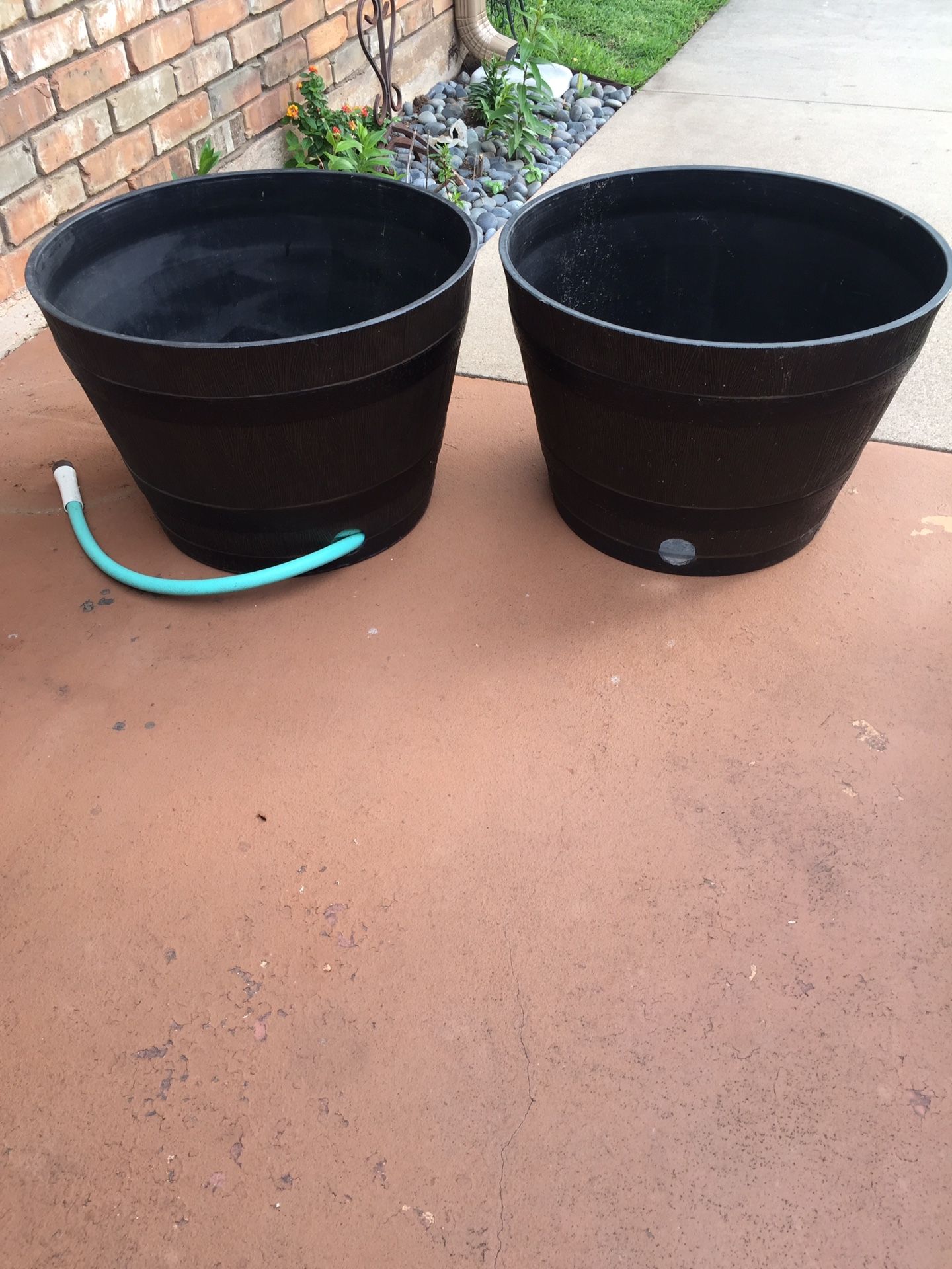 2 BARREL shaped garden hose storage containers. Water hose included. $30.00 for both.