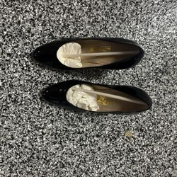 This is a pair of Salvatore Ferragamo black patent leather pumps. 